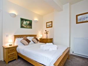 een slaapkamer met een groot bed met 2 nachtkastjes bij 2 Fishermans Loft in Brixham