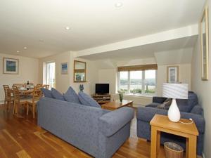 uma sala de estar com um sofá azul e uma mesa em 9 Glendorgal em Saint Columb Minor