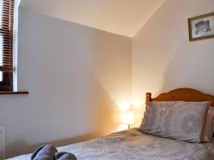 Dormitorio con cama con almohada y lámpara en Inglewood - 15288, en Keswick
