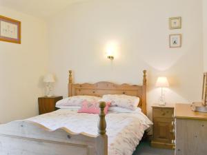 a bedroom with a bed and a desk with two lamps at Harriets Hideaway in Braithwaite