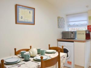 a kitchen with a dining room table and a microwave at Harriets Hideaway in Braithwaite