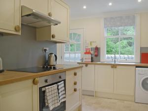 a kitchen with white cabinets and a stove top oven at Fernwoodlea in Blairhall