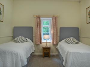 two beds in a room with a window at Fernwoodlea in Blairhall