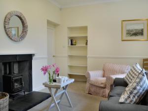 - un salon avec un canapé et une cheminée dans l'établissement Fernwoodlea, à Blairhall