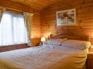 - une chambre avec un lit dans une cabane en rondins dans l'établissement Whiteside Lodge At Burnside Park, à Keswick