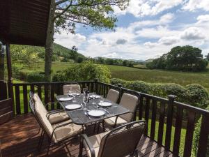 - une table et des chaises sur une terrasse avec vue dans l'établissement Whiteside Lodge At Burnside Park, à Keswick