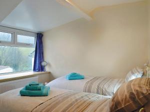 a bedroom with two beds with towels on them at Yr Hen Sgubor in Pentre-briwnant