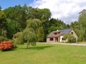 ein Haus mit Sonnenkollektoren auf dem Dach in der Unterkunft Pinewood in Gairlochy