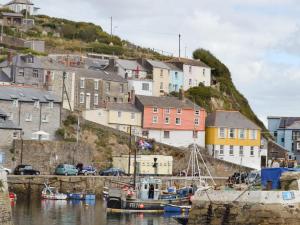 a boat docked in a harbor with houses on a hill at Tranquility - 28004 in Mevagissey