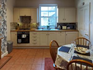 uma cozinha com uma mesa e uma mesa e uma mesa e cadeiras em Squirrel Cottage em Thornton Dale