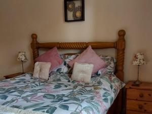 um quarto com uma cama com almofadas em Squirrel Cottage em Thornton Dale