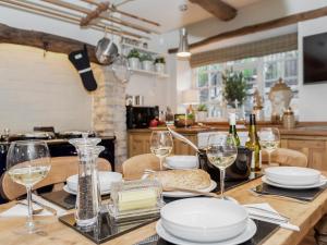 une table avec des verres et des assiettes dans une cuisine dans l'établissement Narrowgates Cottage, à Barrowford