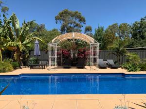 a white gazebo next to a swimming pool at Bungala House in Yankalilla