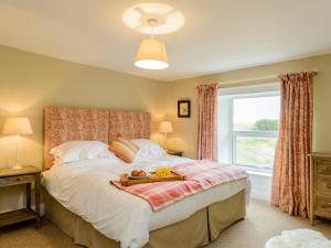 a bedroom with a bed with a tray of food on it at Backstone Bank Farmhouse in Wolsingham