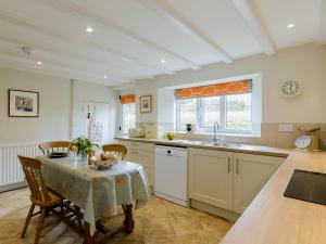 una cocina con mesa y mantel. en Backstone Bank Farmhouse, en Wolsingham