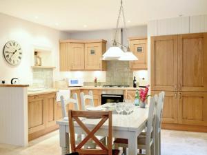 a kitchen with a table and chairs and a clock at Ardbhan Croft in Oban