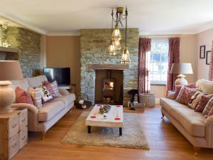 a living room with a couch and a fireplace at Fountain Hill in Eglwyswrw