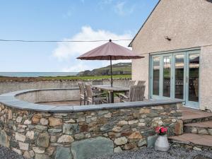 a patio with an umbrella and a table and chairs at Stack View Cottage in Holyhead