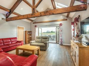 a living room with a red couch and a table at Stack View Cottage in Holyhead