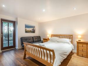 a bedroom with a bed and a couch at Stack View Cottage in Holyhead