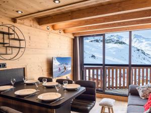 ein Esszimmer mit einem Tisch und einem großen Fenster in der Unterkunft Appartement rénové duplex - Val Thorens, 6 pers - proche pistes - FR-1-637-58 in Val Thorens