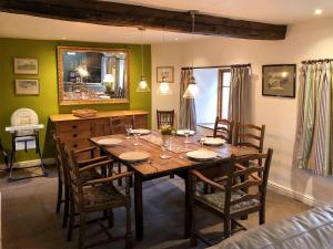 a dining room with a table with chairs and a mirror at Little Knott in High Nibthwaite