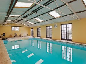 a pool with blue water in a building with windows at Dairy Cottage in Abergavenny