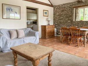 a living room with a couch and a table at Dairy Cottage in Abergavenny