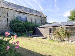 an old stone house with a garden and flowers at Dairy Cottage in Abergavenny