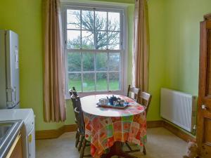 a kitchen with a table in front of a window at Millford House in Hartland