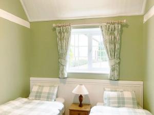 a bedroom with two beds and a window at Valley Farm Cottage in Sudbourne