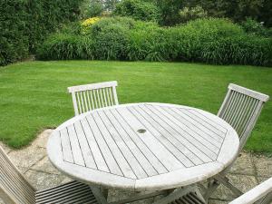 ein Holztisch und zwei Stühle neben einem Rasen in der Unterkunft Valley Farm Cottage in Sudbourne