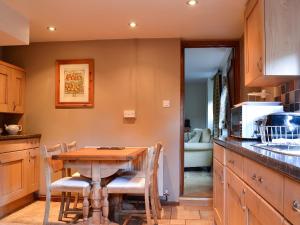 a kitchen with a table and chairs in a kitchen at The Cot in Chalford