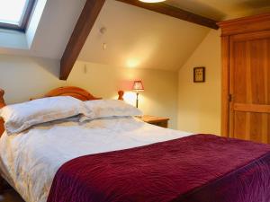a bedroom with a large bed and a window at The Cot in Chalford