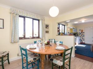 a dining room with a wooden table and chairs at Seagulls in Blakeney