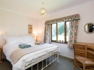 a bedroom with a bed and a window at Seagulls in Blakeney