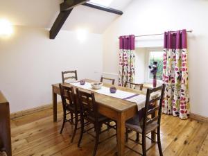 a dining room with a wooden table and chairs at Deuglawdd Cottage - Hw7788 in Aberdaron