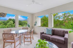 a living room with a couch and a table and chairs at Vacanze A Casa - Resort Just Minutes From The CBD in Cairns North
