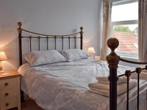 a bedroom with a large bed with a window at Albion Cottage in Pakefield
