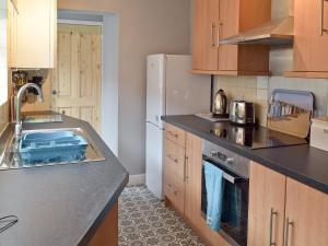 a kitchen with a sink and a refrigerator at Albion Cottage in Pakefield