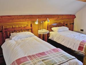 a bedroom with two beds and a table in it at Tre Fardre in Kinmel