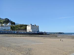 a beach with a pier and buildings in the background at Tre Fardre in Kinmel