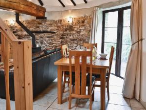 comedor con mesa de madera y sillas en Oak Cottage en Woolfardisworthy