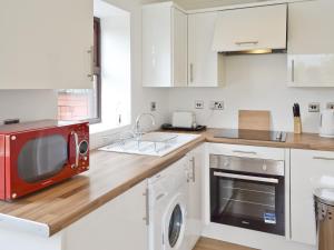 a kitchen with a red microwave on a counter at Bellwood House Annexe in Felixkirk