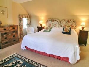 a bedroom with a large white bed and a dresser at Dhuallow in Aberarder