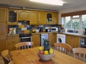 a kitchen with a table with a bowl of fruit on it at Ponsgwedhen in Coverack
