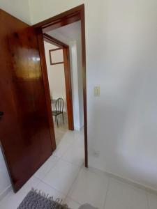 a hallway with a wooden door and a table at Apartamento Martin de Sá in Caraguatatuba