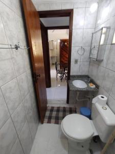 a bathroom with a toilet and a sink at Apartamento Martin de Sá in Caraguatatuba