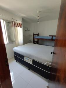 a bedroom with a bed in a room at Apartamento Martin de Sá in Caraguatatuba