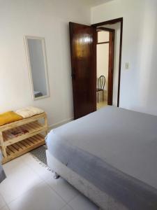 a bedroom with a bed and a mirror and a table at Apartamento Martin de Sá in Caraguatatuba